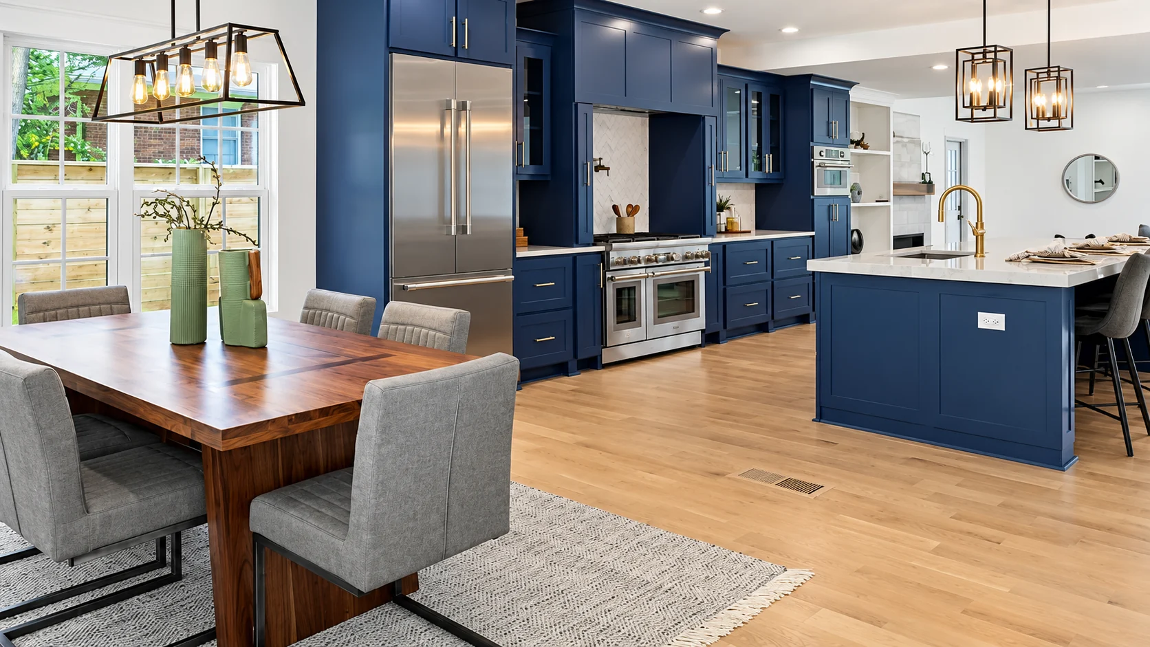 Elite's kitchen renovation with deep blue cabinets, a quartz island and warm wood floors